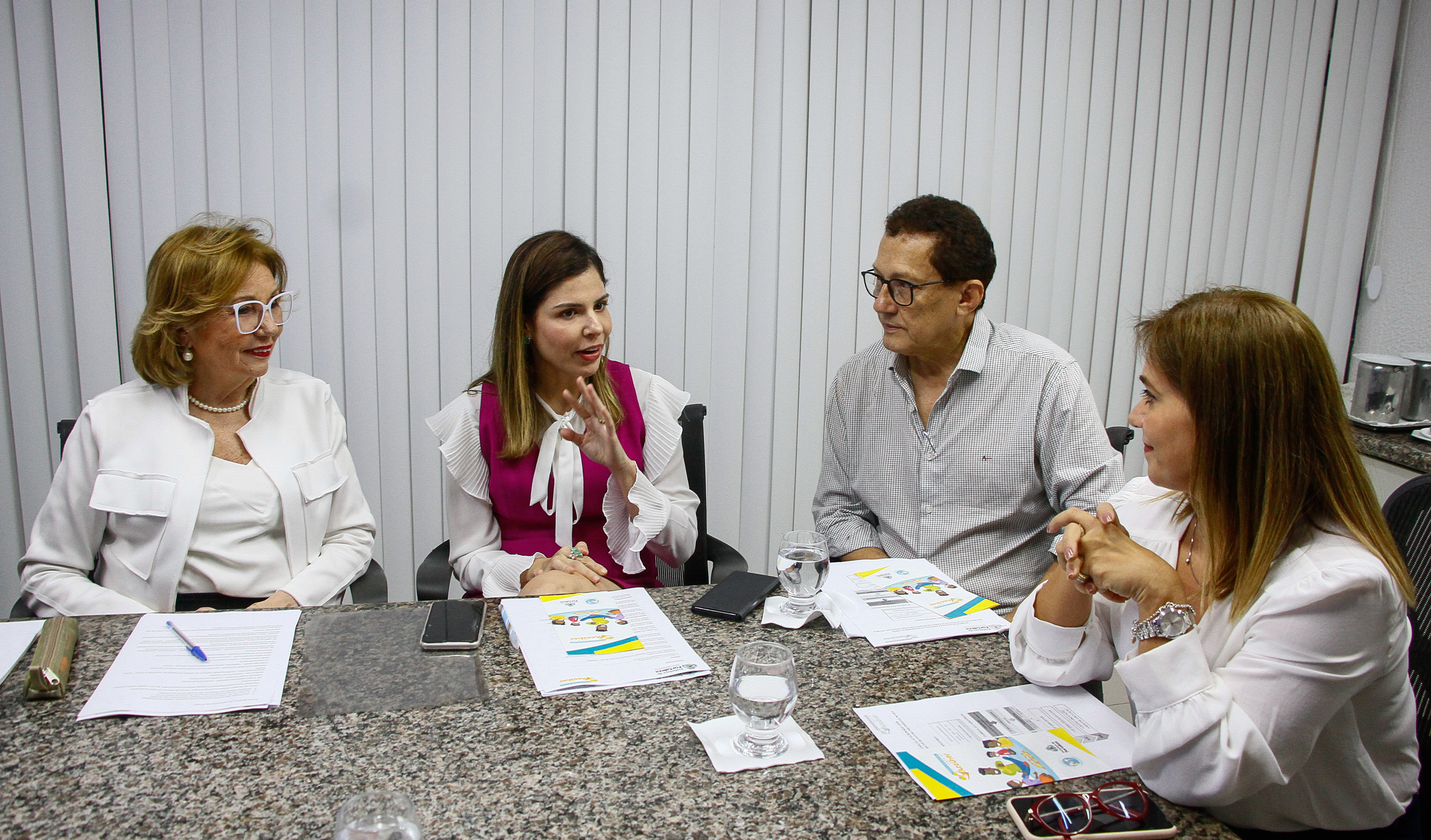 primeira-dama sentado em mesa conversando com senhor e duas mulheres sentados ao redor